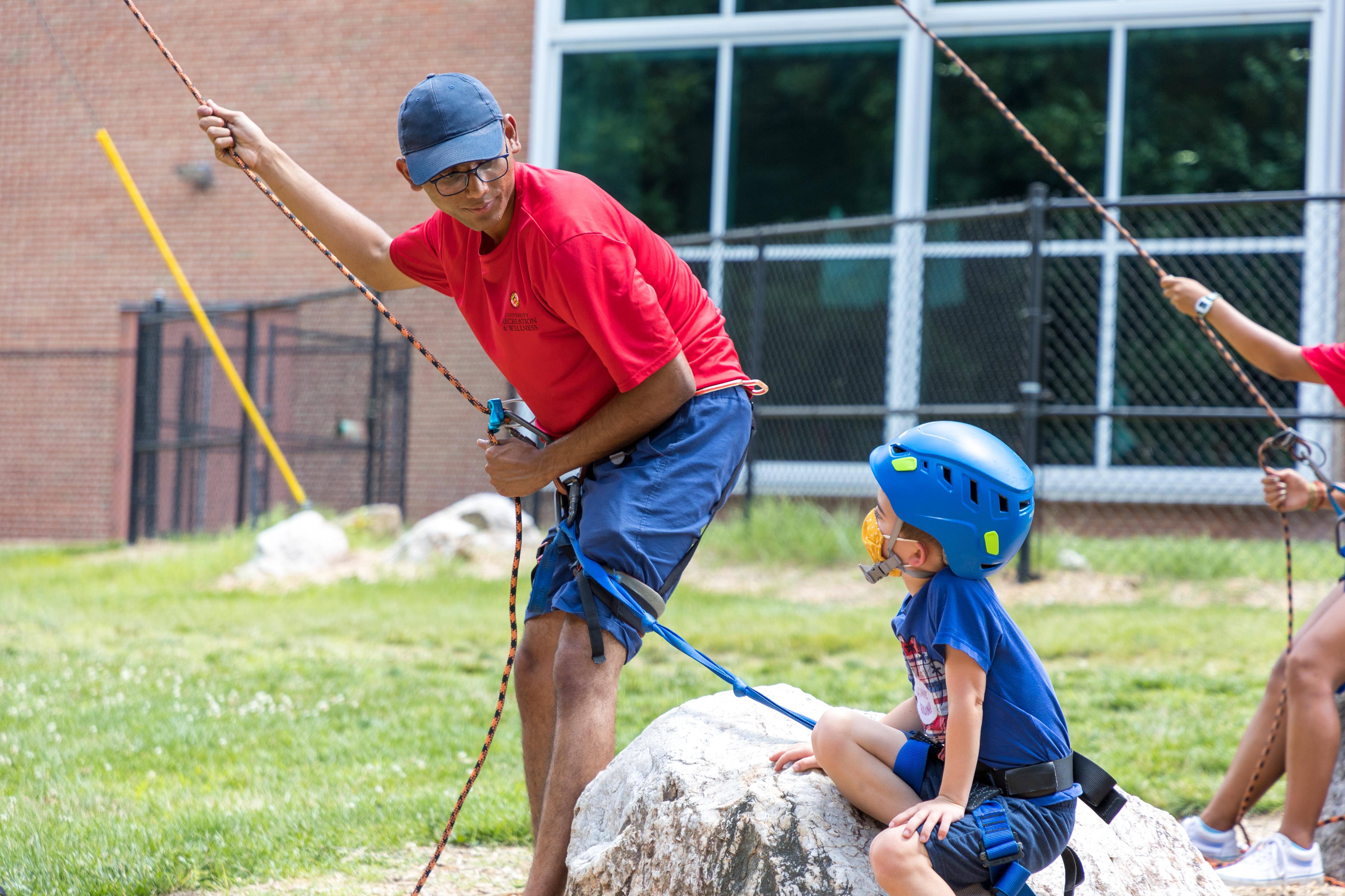 climbing wall instructor speaking to child