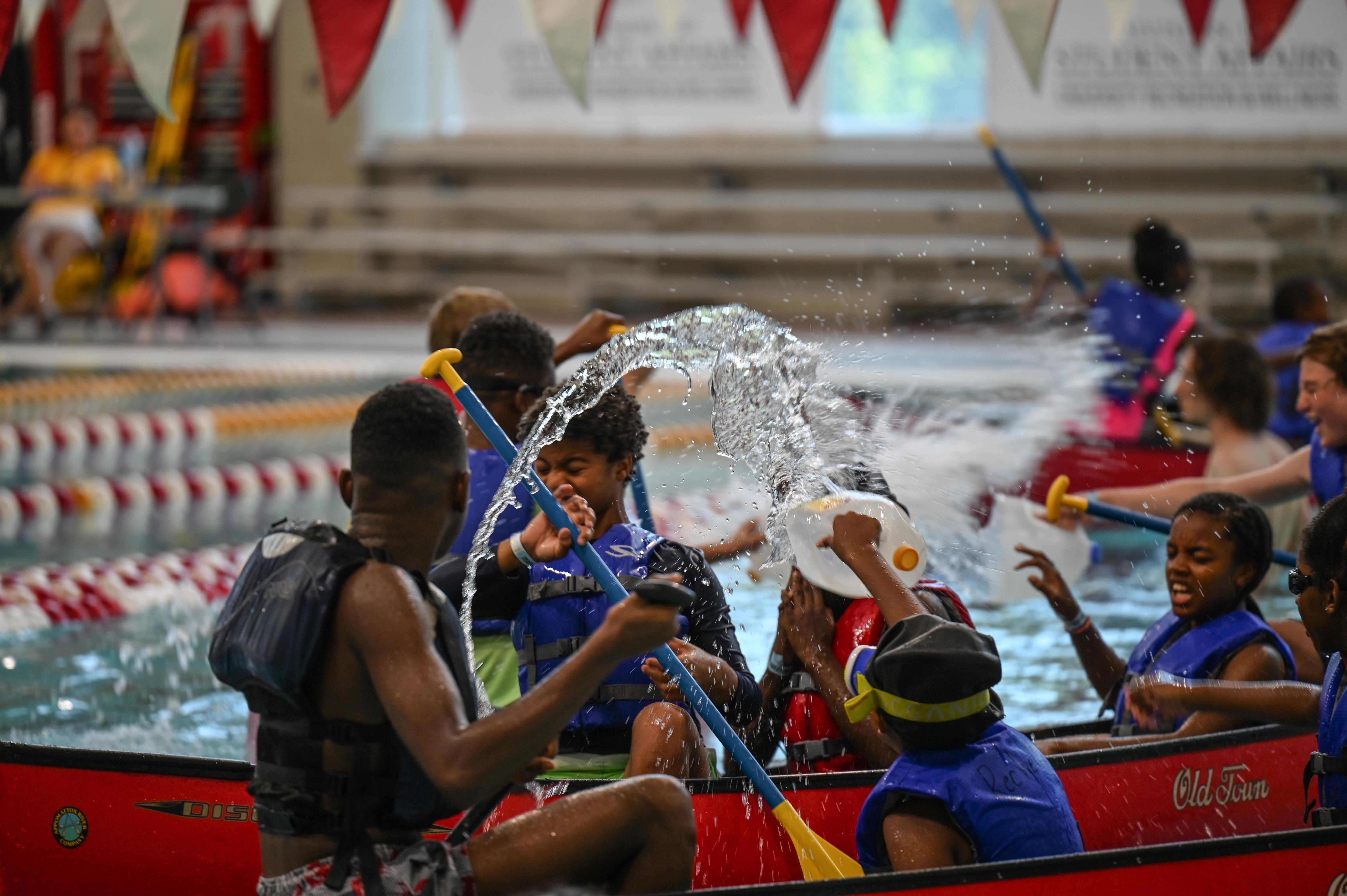 Campers splashing in the pool from a canoe