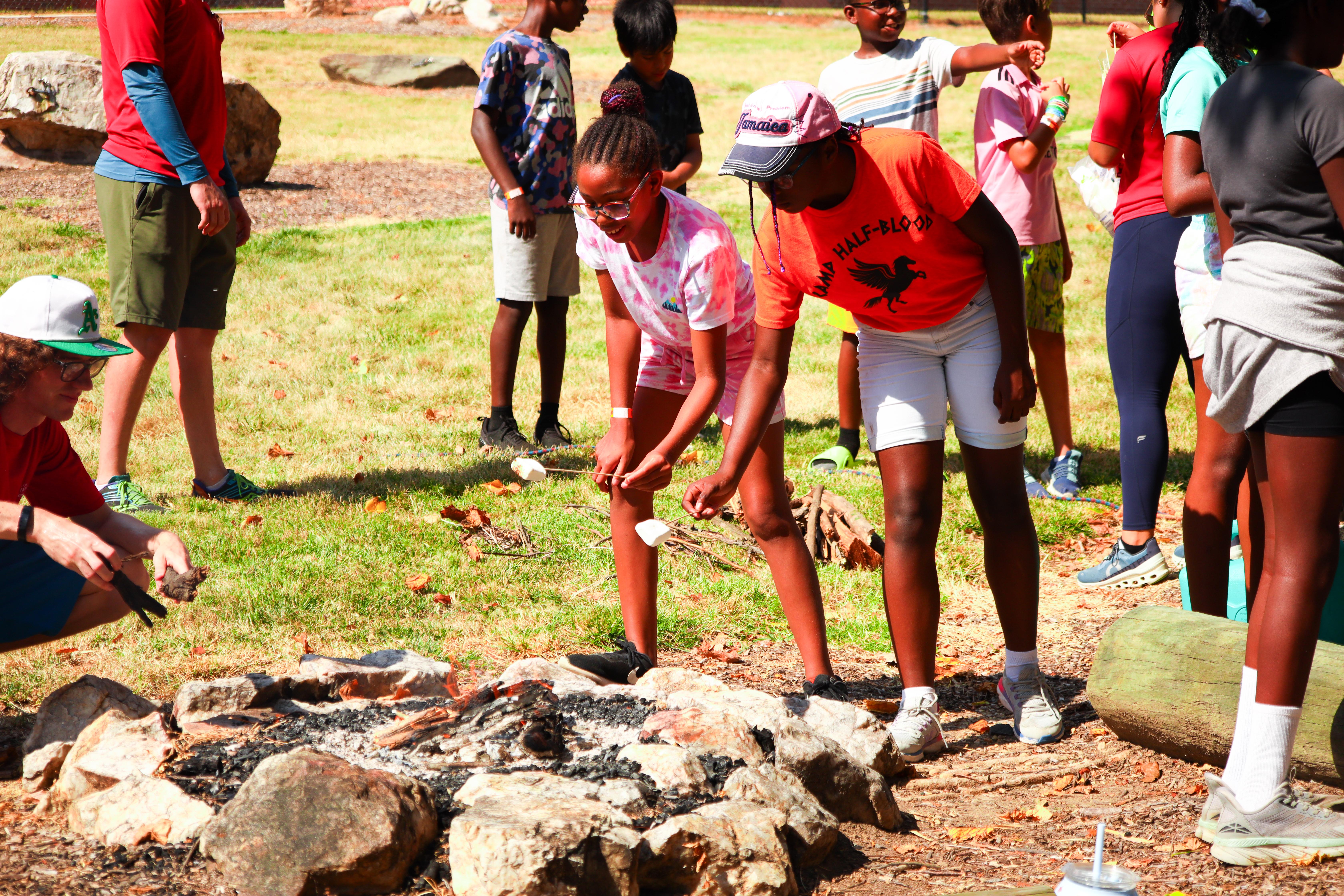 Campers roast marshmallows at a campfire